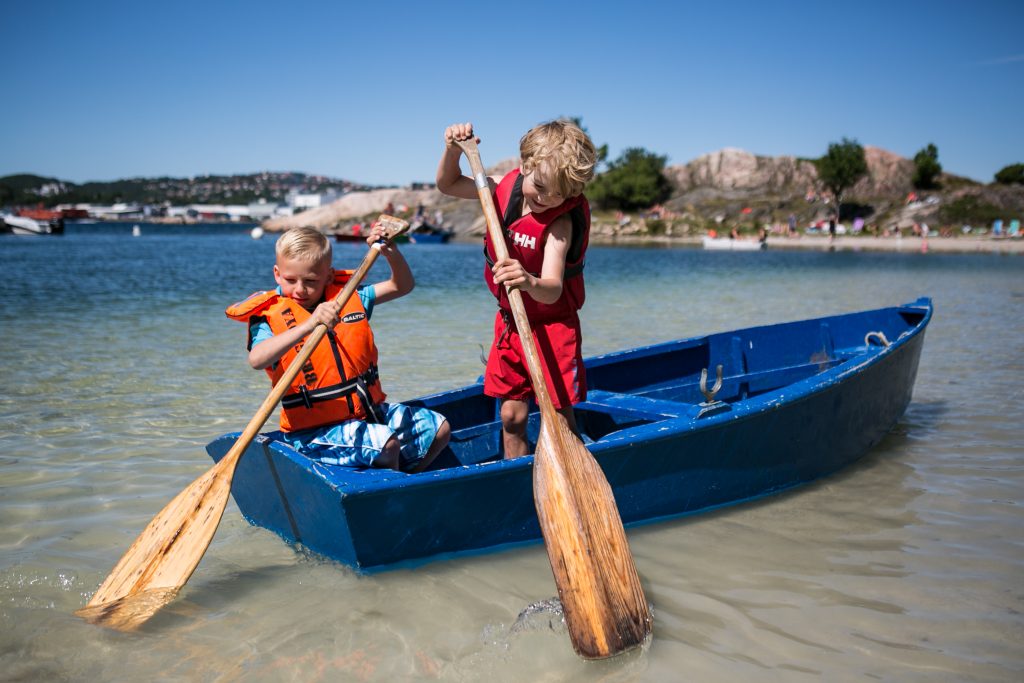 På sommerleir på Barnas Øy. Gutter som padler i liten båt på Bragdøya utenfor Kristiansand
